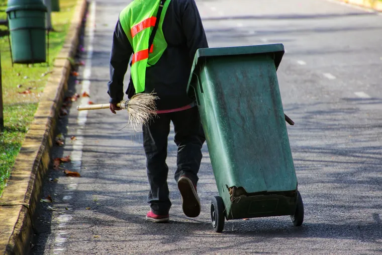 Worker sweeping a city street